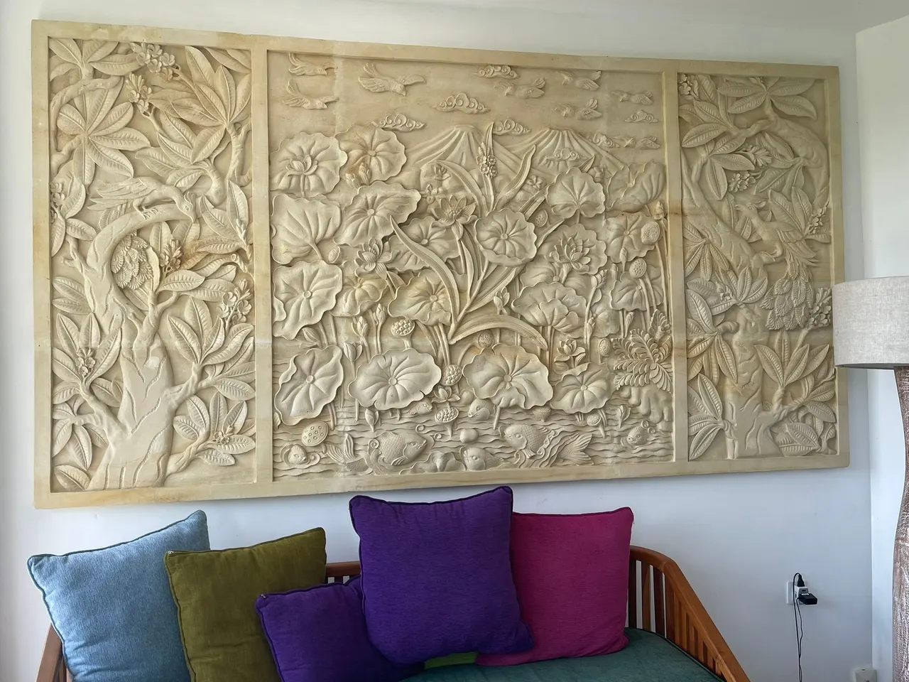 Floral stone relief above a lounge with jewel-toned cushions