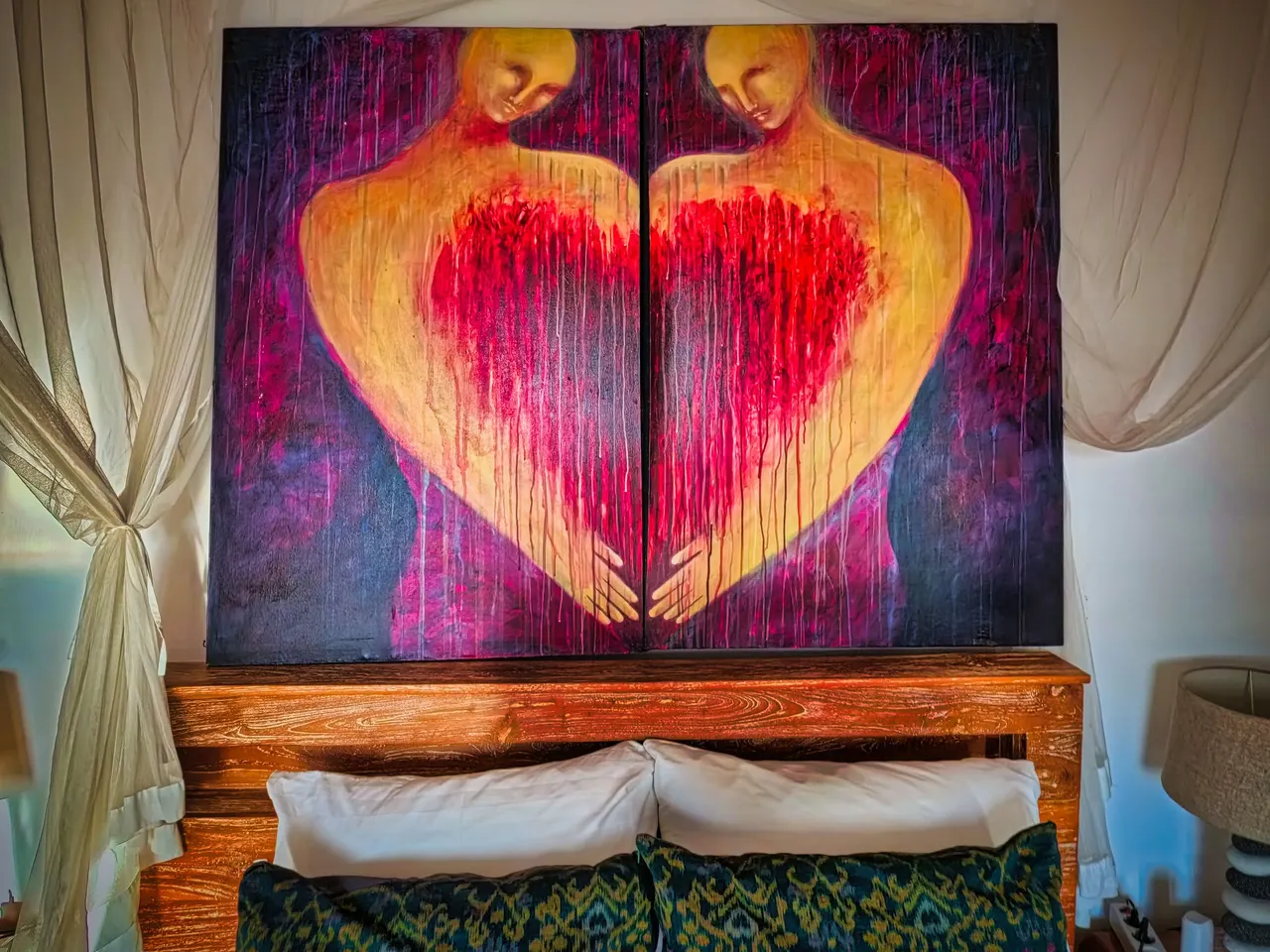 Large original painting of hands forming a heart above a bed