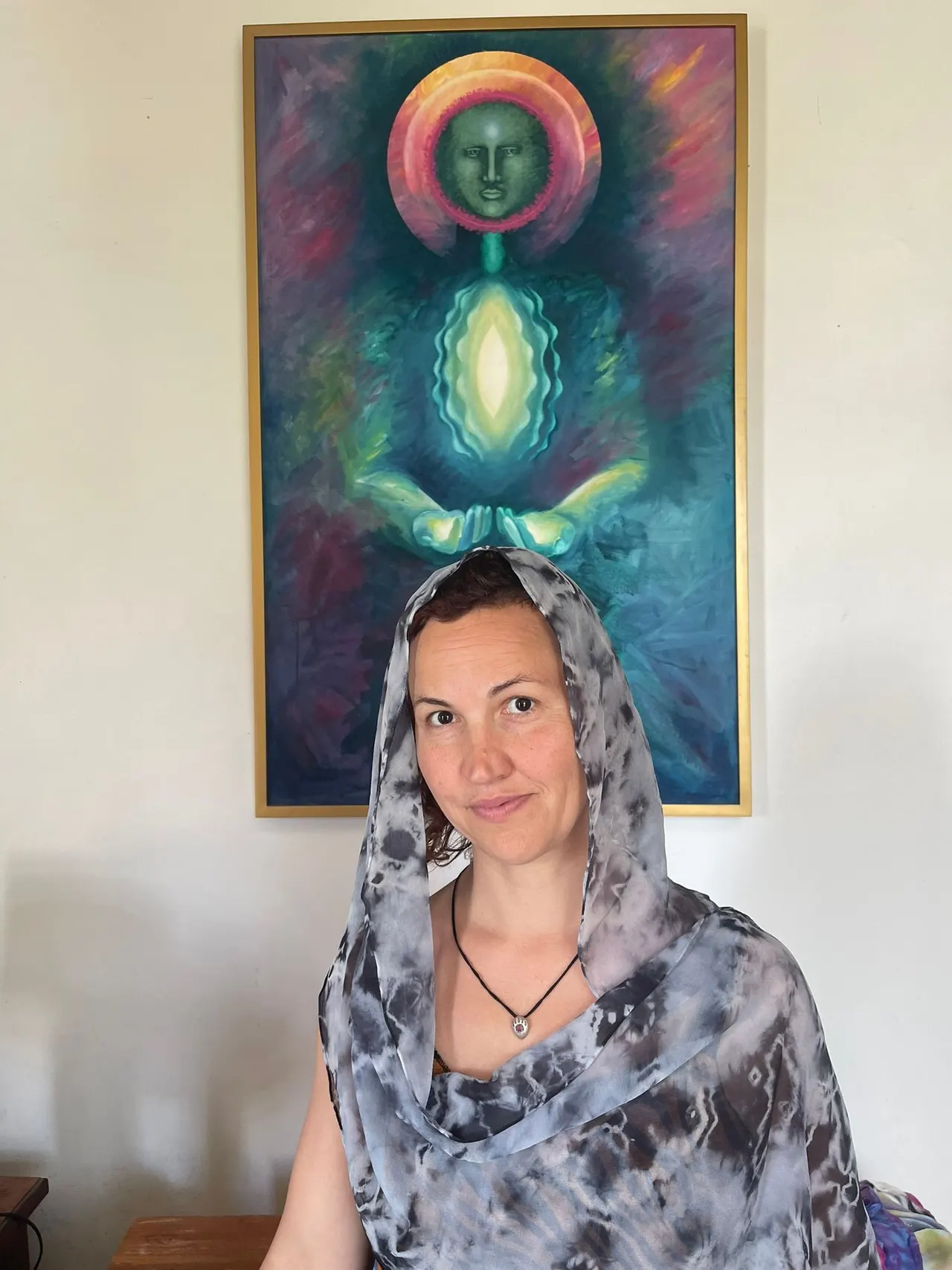 Guest in a hand-dyed scarf beneath a lotus painting