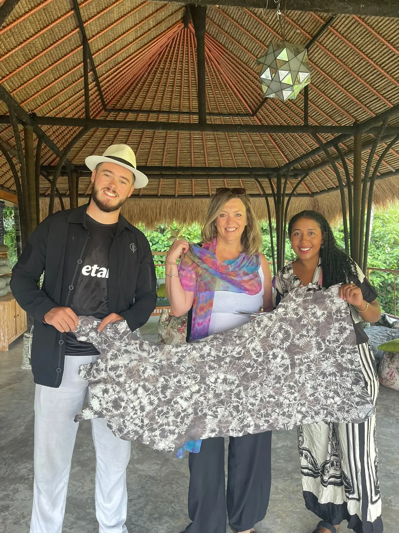 Guests holding a hand-dyed cloth in the open-air bale