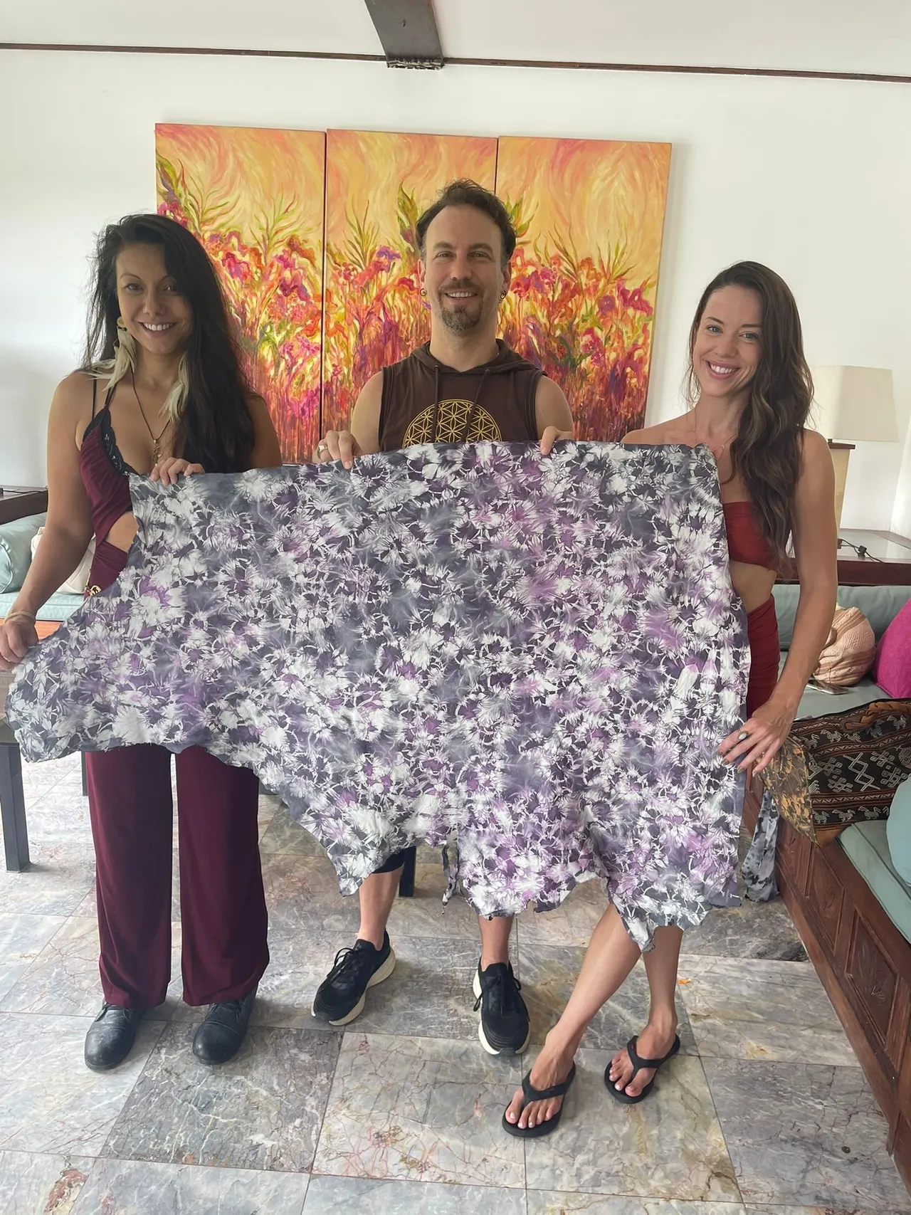 Three guests holding up their violet dyed cloth