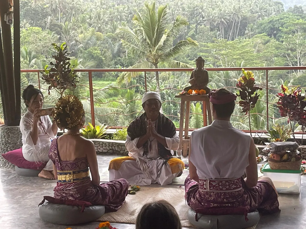 Guests in Balinese dress at a blessing ceremony led by a priest