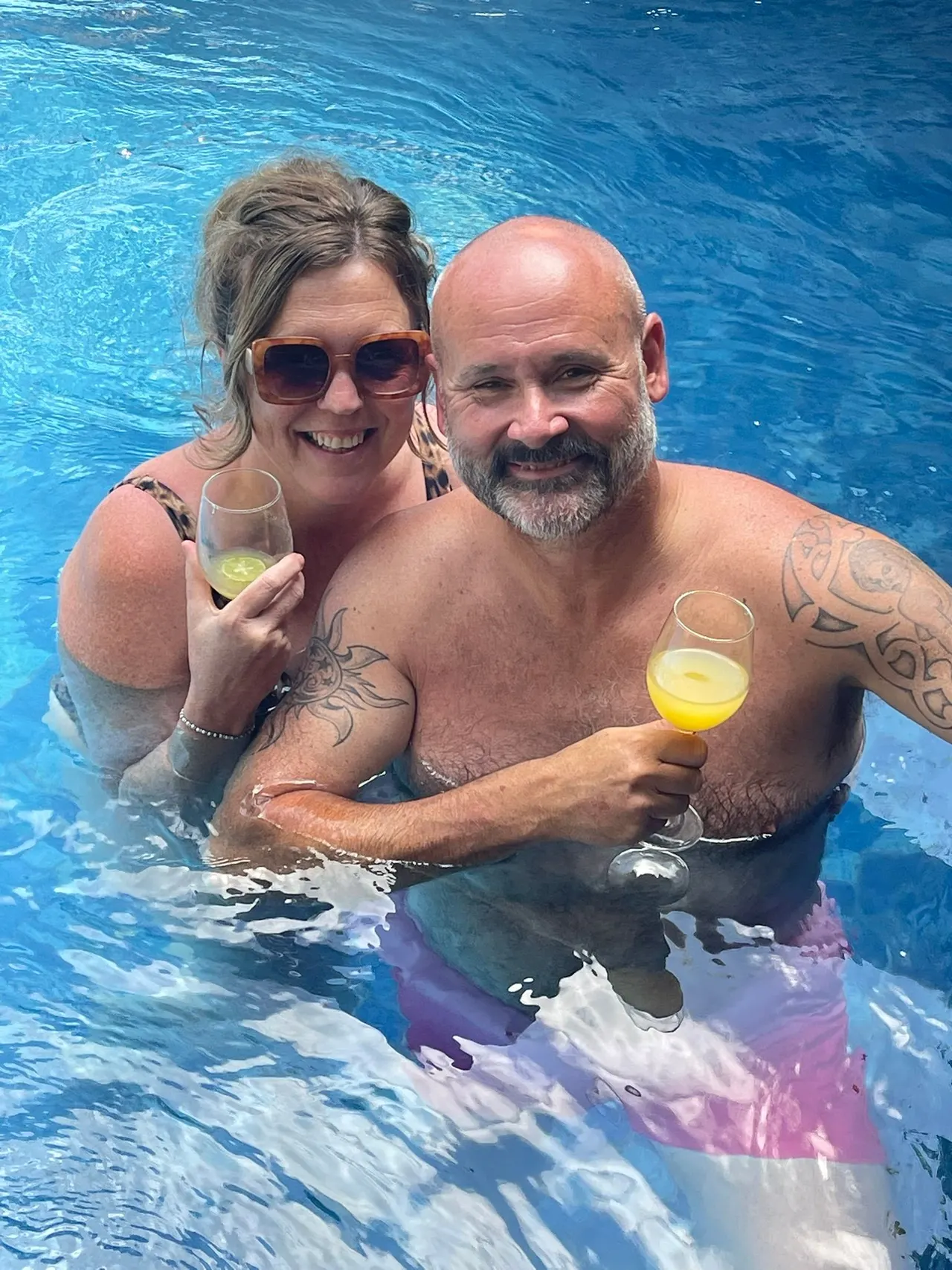 Couple raising a toast in the infinity pool