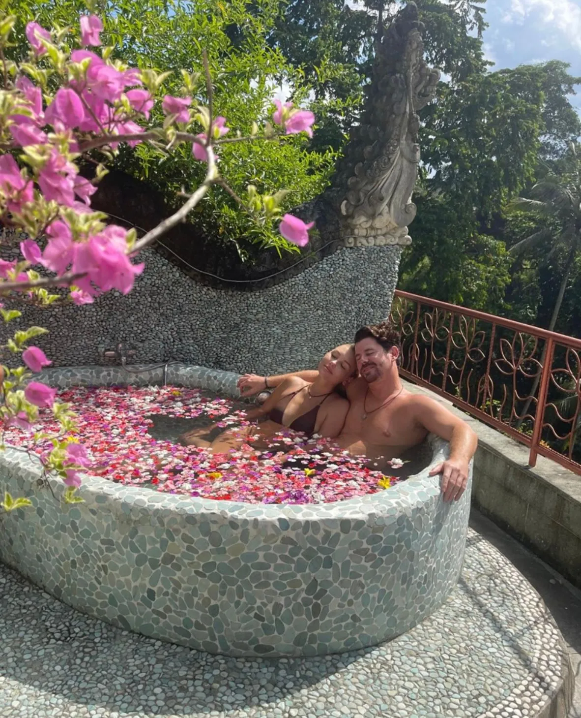 Couple relaxing in an outdoor flower bath at River Song