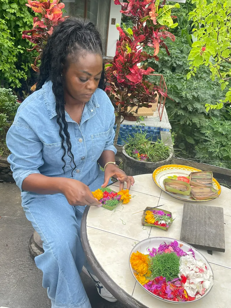 Guest arranging flower offerings at the garden table